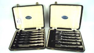 Two sets of six silver handled cake knives and forks,