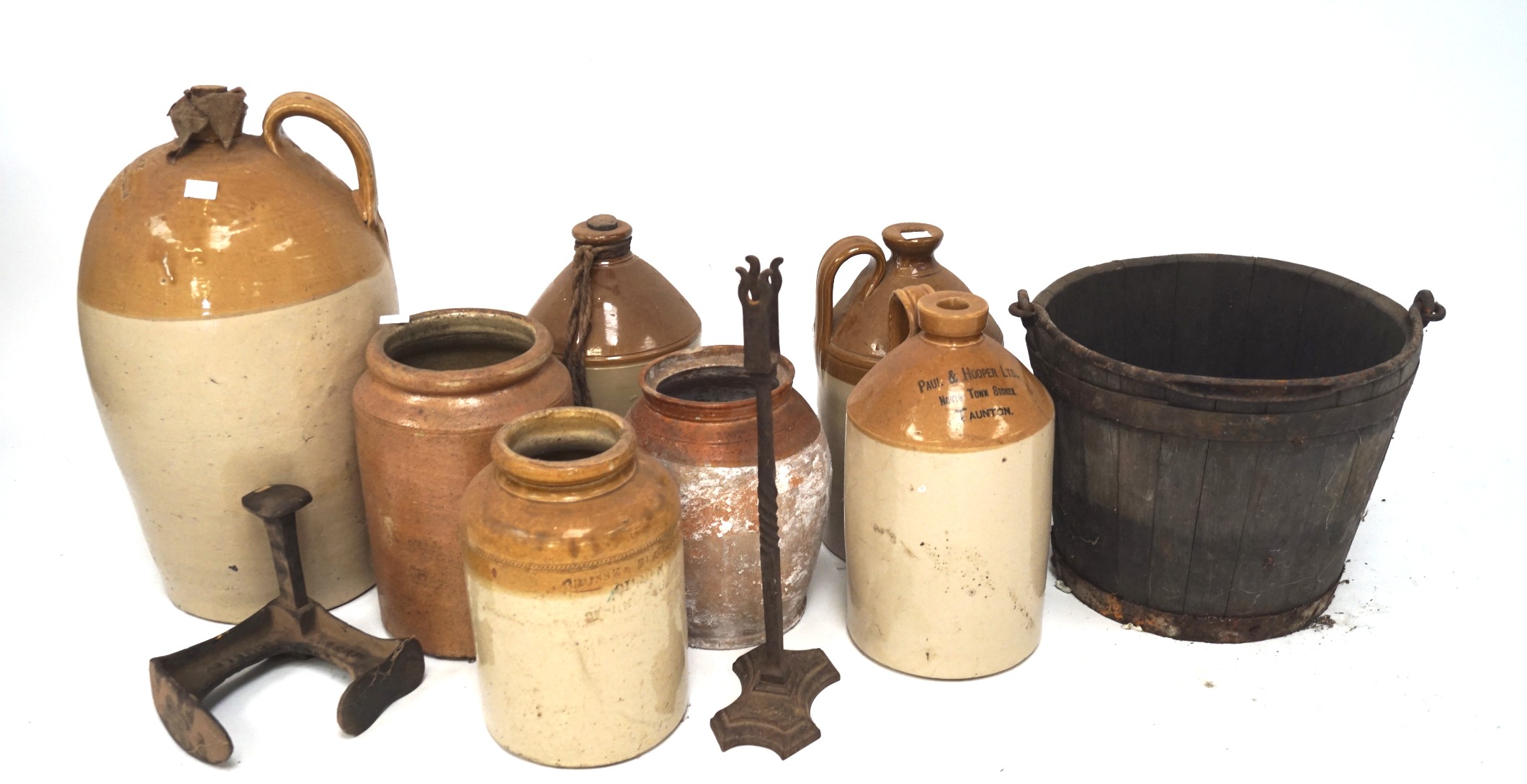 A large collection of stoneware flagons, of assorted sizes and designs,