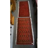 Two small Turkaman rugs with beige and black patterns on a red ground,