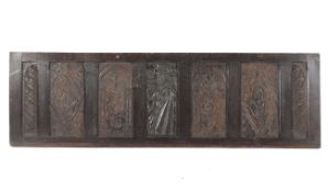 A framed 16th century oak relief carved panel and six later carved panels,