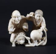 A late 19th century Japanese carved ivory okimono, depiciting a couple with a monkey and an octopus,