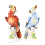 A pair of Sitzendorf porcelain parrots, modelled on a tree stump, blue marks to base,