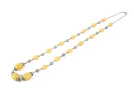 An early 20th century yellow amber necklace of three similar sized beads and fourteen smaller beads