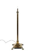 A brass corinthian column standard lamp, raised on lion paw feet,