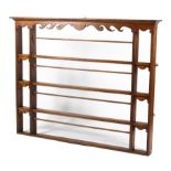 A Victorian oak four tier hanging plate rack, with scroll carved frieze and details,