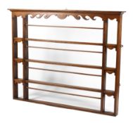 A Victorian oak four tier hanging plate rack, with scroll carved frieze and details,