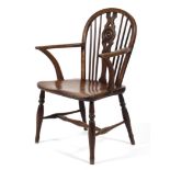 An elm low windsor chair, with wheel and spindle back, on turned baluster legs and stretchers,