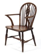 An elm low windsor chair, with wheel and spindle back, on turned baluster legs and stretchers,