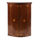 A Georgian mahogany corner cupboard, D-shaped, inlaid with satinwood fan medallions,