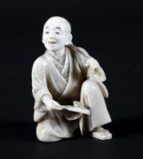 A late 19th century Japanese carved ivory okimono depiciting a seated gentleman taking tea,