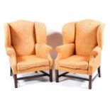 A matched pair of Georgian style wing back arm chairs,