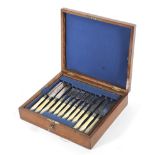 An Edwardian oak cased canteen with silver plated and ivory mounted flatware,