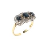 An 18ct gold and sapphire dress ring the central sapphire flanked by two smaller