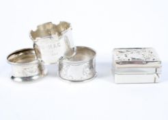 Three assorted silver napkin rings and a silver topped stamp box,