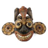 A large carved and painted wooden tribal wall mask, possibly Polynesian,