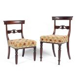 Four mid-19th century mahogany dining chairs, each top rail carved with scrolling leaves,
