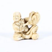 A late 19th century ivory netsuke of a seated man holding a sack on his knee, signed Senko (?),