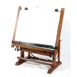 An early 20th century pine adjustable drawing board on stand,