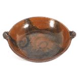 A large Staffordshire earthenware slipware two-handled shallow bowl, 20th century, incised W mark,