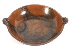 A large Staffordshire earthenware slipware two-handled shallow bowl, 20th century, incised W mark,