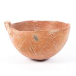 An early Bronze Age polished red earthenware bowl, incised with zig-zag ornament,
