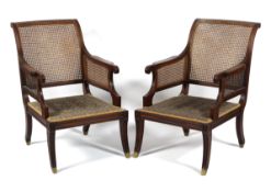A pair of Regency-style mahogany bergere library armchairs, early 20th century,