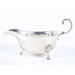 A silver sauceboat, with C scroll handle raised on the hoof feet, maker Adie Bros, Birmingham, 1937,