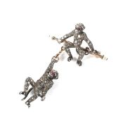 A white metal bar brooch of unusual form depicting a seated chimpanzie and one other hanging from