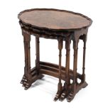 A Victorian nest of three walnut spider-legged tables, each with shaped oval moulded top,