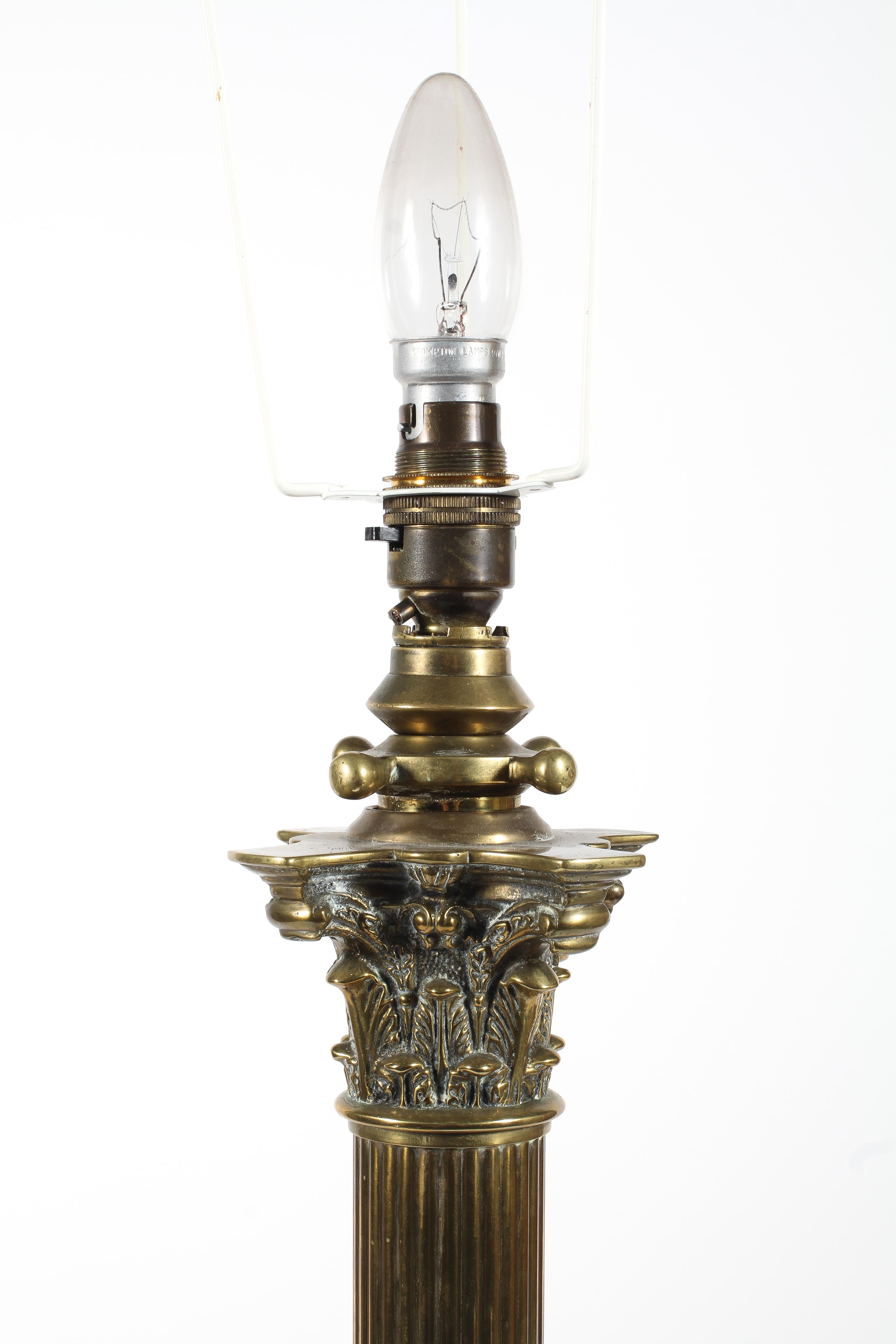 A brass corinthian column standard lamp, raised on lion paw feet, - Image 2 of 2
