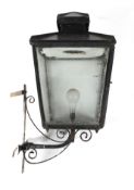 A black painted metal lantern, the glazed shade adapted for electricity,