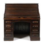 A 1940's oak roll top pedestal desk, the tambour lid enclosing a fully fitted interior,