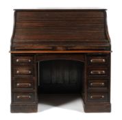 A 1940's oak roll top pedestal desk, the tambour lid enclosing a fully fitted interior,