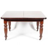 A Victorian mahogany wind out dining table, with two extra leaves,