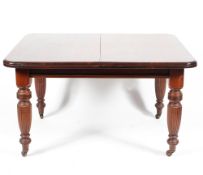 A Victorian mahogany wind out dining table, with two extra leaves,