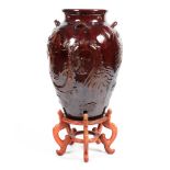 A large 20th century treacle glazed Oriental vase on stand decorated with four toed dragons
