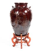 A large 20th century treacle glazed Oriental vase on stand decorated with four toed dragons