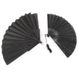 Two 20th century folding fans, one with with a black and red fabric leaf painted with flowers,