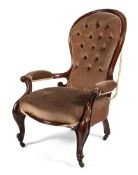 A Victorian button back mahogany framed armchair, with spoon-shaped back,