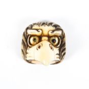 A 19th century ivory netsuke of a karasu tengu mask, inlaid pupils (one missing), signed Masakazu,