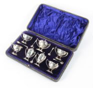 A silver cased seven piece cruet set, comprising four salts,