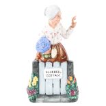 A Royal Doulton figure of an old lady at her cottage gate, titled 'Thank You', printed green marks,