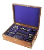 An oak and brass mounted canteen of Maple cutlery, containing a set of 12 silver-plated spoons,