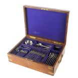 An oak and brass mounted canteen of Maple cutlery, containing a set of 12 silver-plated spoons,