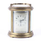 A French oval brass carriage clock, early 20th century, the silvered dial with Arabic numerals,