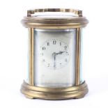A French oval brass carriage clock, early 20th century, the silvered dial with Arabic numerals,