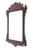 A Georgian mahogany framed mirror, with scolling foliate cresting and mantling,
