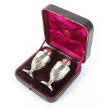 A boxed silver pedestal salt and pepper shaker, with gadrooned decoration,