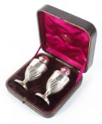 A boxed silver pedestal salt and pepper shaker, with gadrooned decoration,