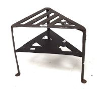 An Arts and Craft style early 20th century cast metal stand, of triangular form with two tiers,